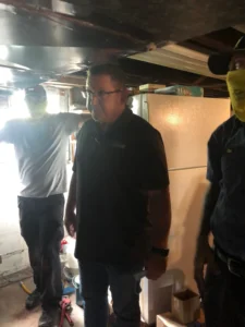 The Top Notch Heating, Cooling & Plumbing team posing in front of a client's home and A/C unit.