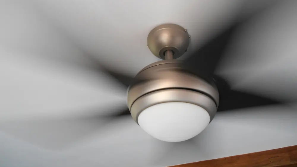 A ceiling fan, mid-spin.