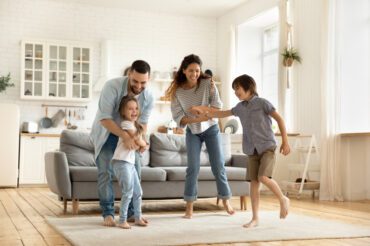 family of four playing in the living room