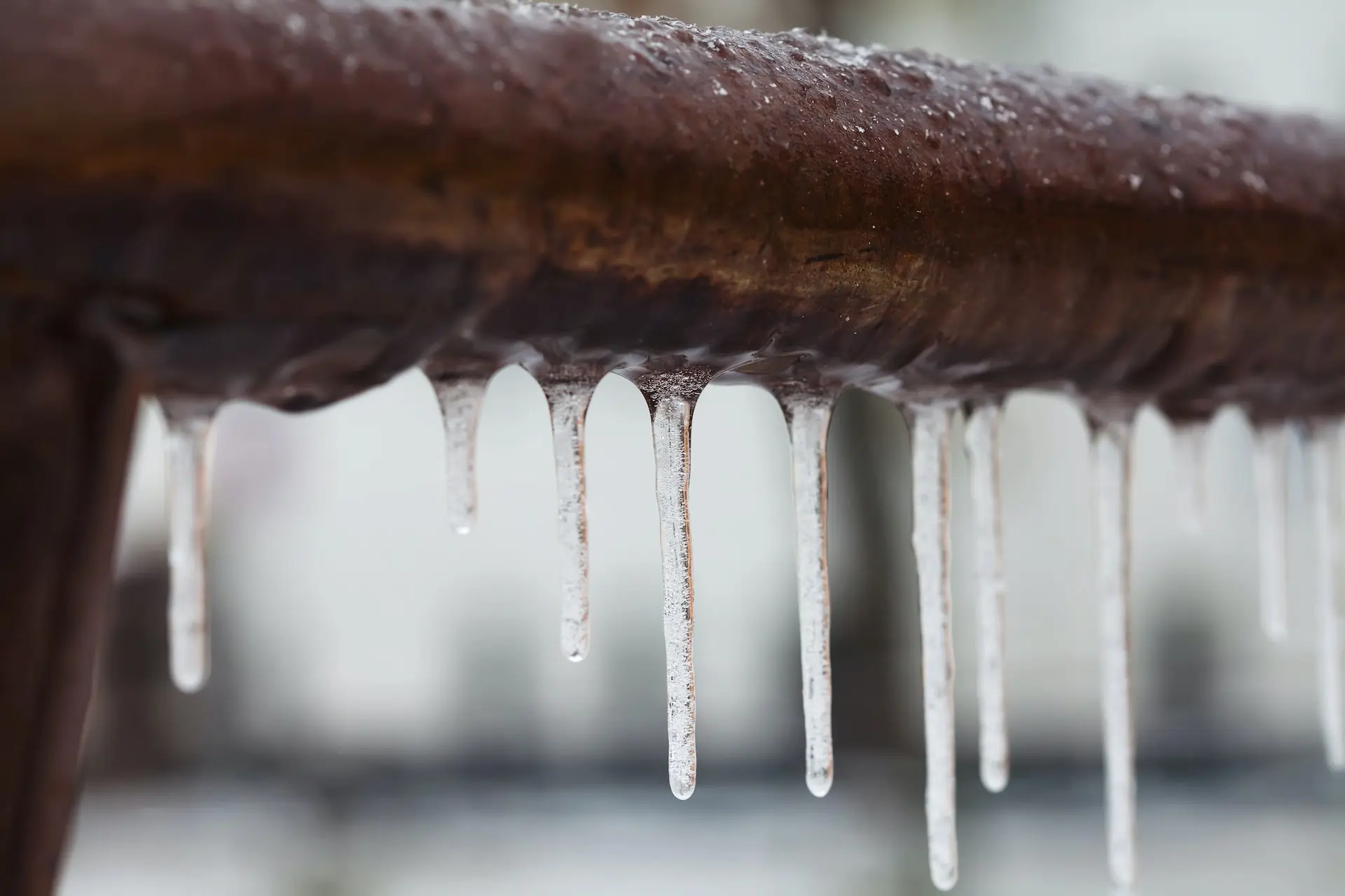 A frozen pipe with small icicles.