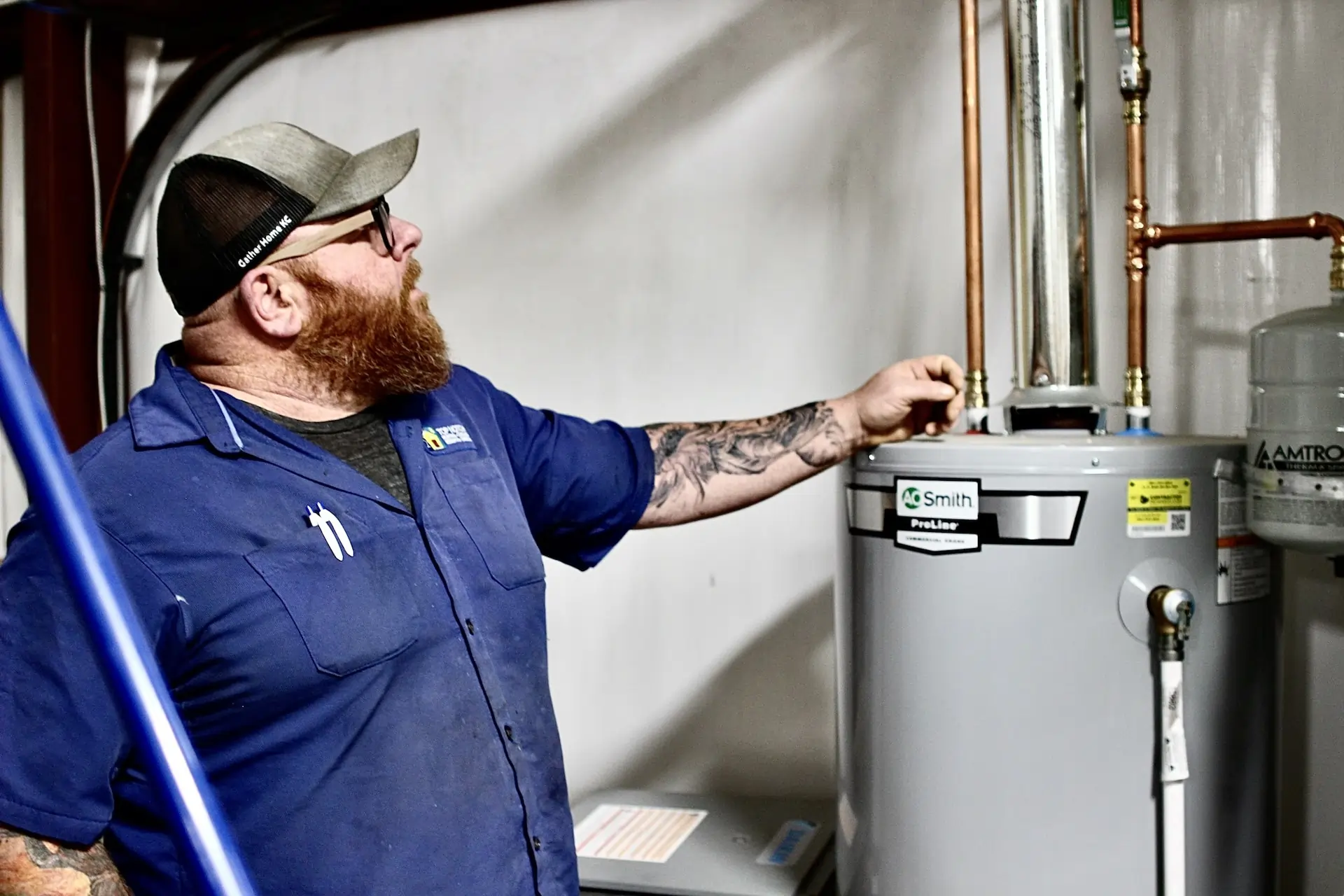 A Top Notch Heating, Cooling & Plumbing technician working on a water heater.