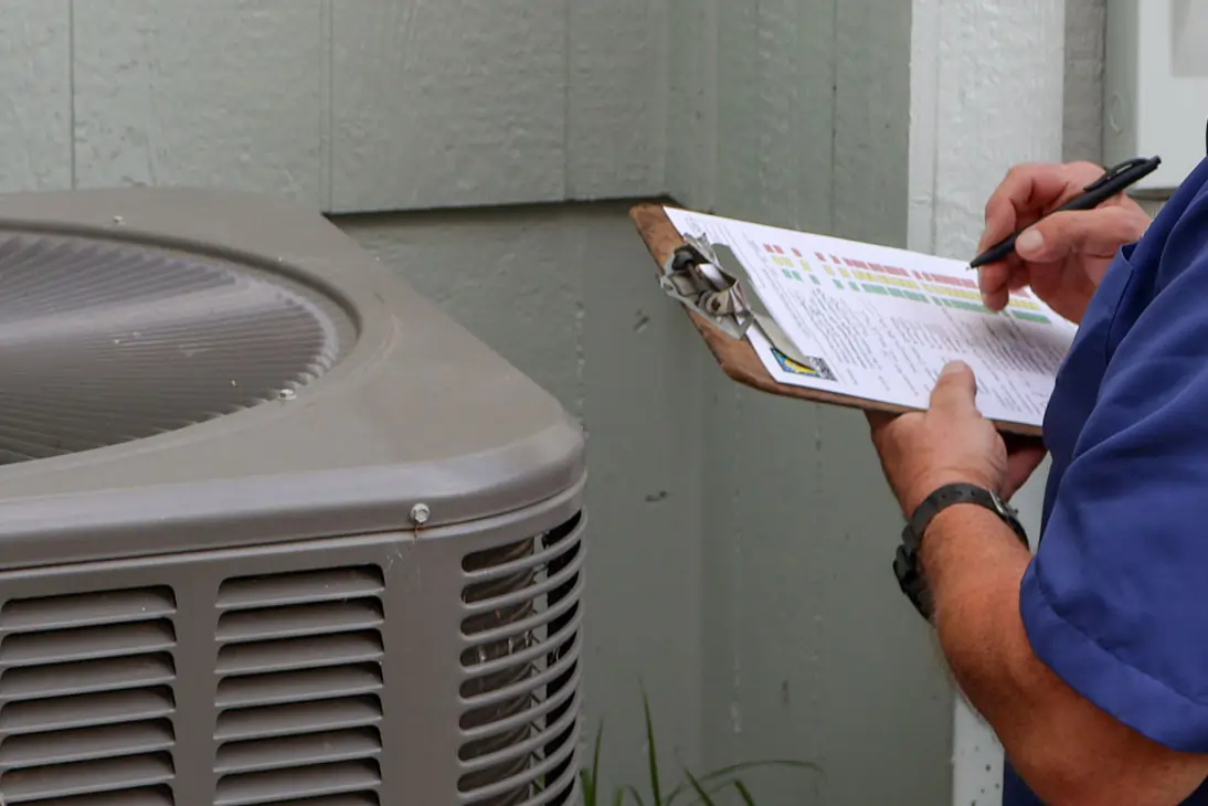 Top-Notch-Heating-Cooling-and-Plumbing-AC-maintenance A Top Notch Heating, Cooling & Plumbing technician with clipboard and inspection checklist at a Kansas City home.