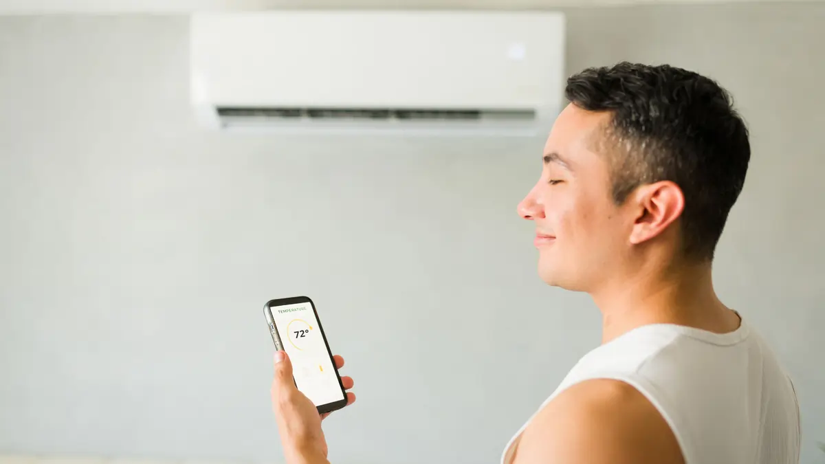 Kansas City homeowner adjusting a mini split remote Top Notch Heating Cooling Plumbing