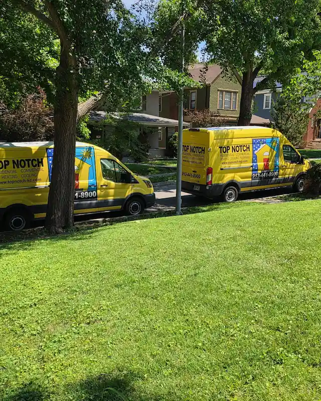 Top Notch Heating, Cooling & Plumbing vans outside Kansas City home